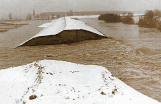 When businesses can no longer sustain profit losses due to increases in input costs, the resulting selling price increases would be comparable to a dike breaking. Sepia photo image of a dike break due to floods.