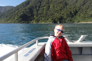 boy on a boat with trees in the background