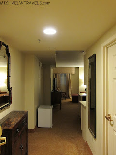 a hallway with a mirror and a dresser
