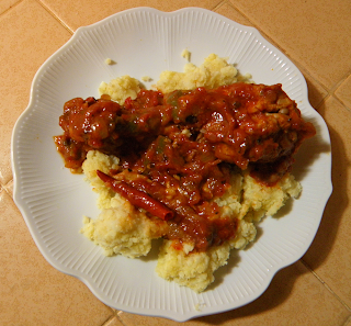 Red Chili on Plate of Chicken in Red Pepper Sauce over Millet