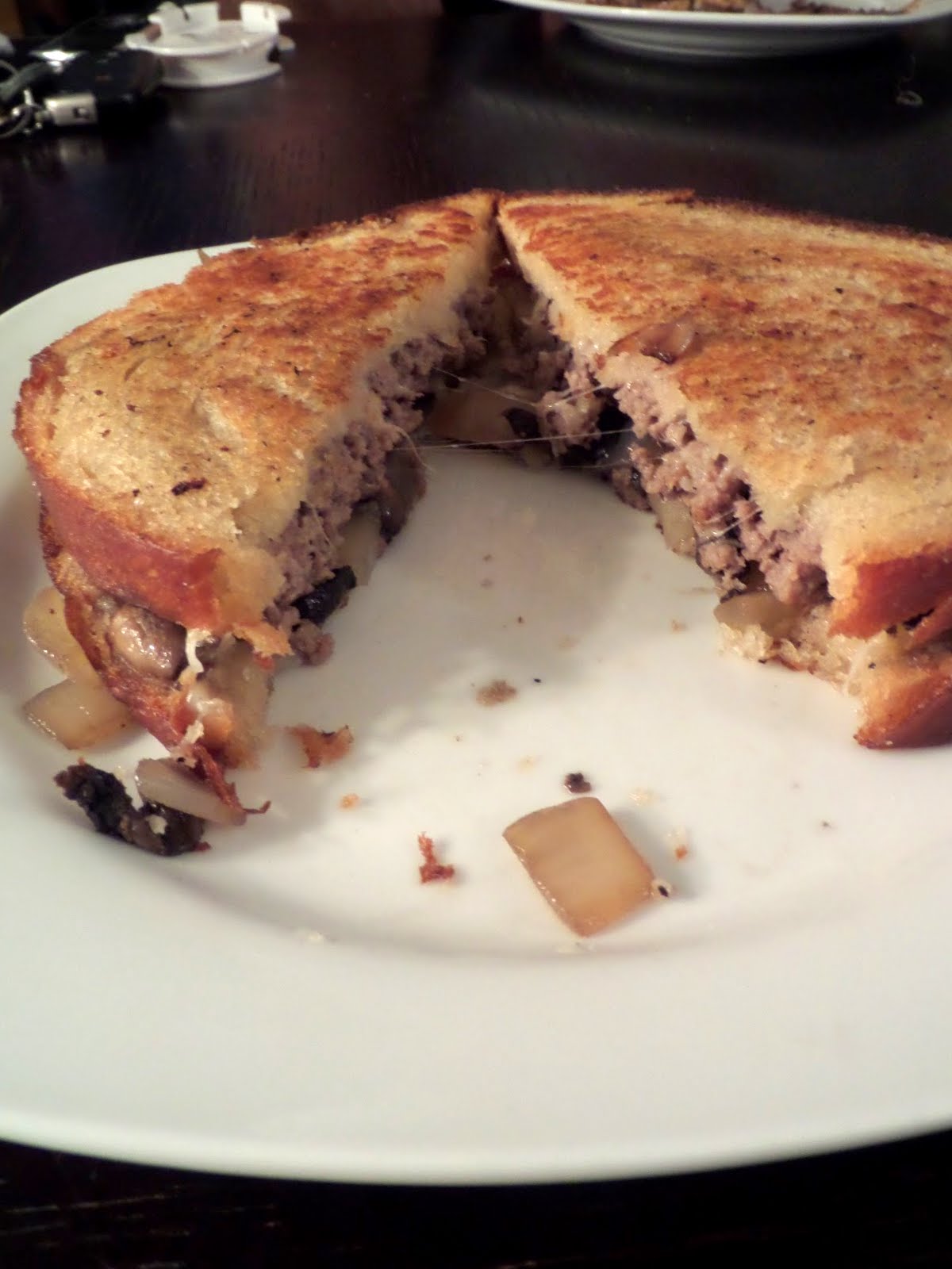 Mushroom and Swiss Patty Melt:  A burger patty, Swiss cheese, and sauteed mushrooms and onions, sandwiched between 2 slices of bread then grilled until hot and melty.
