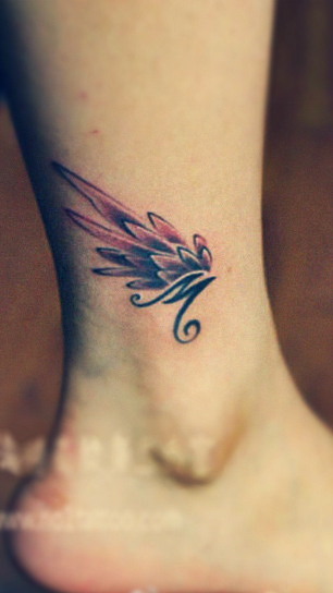 An angel wing tattoo on the ankle with a letter M