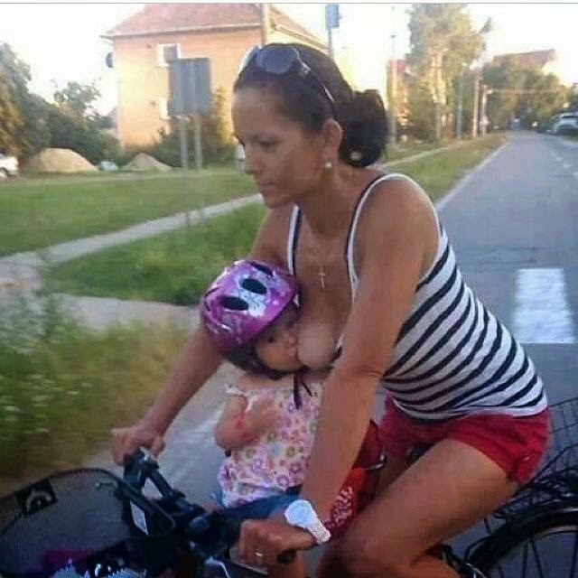 Mother nursing on bike.
