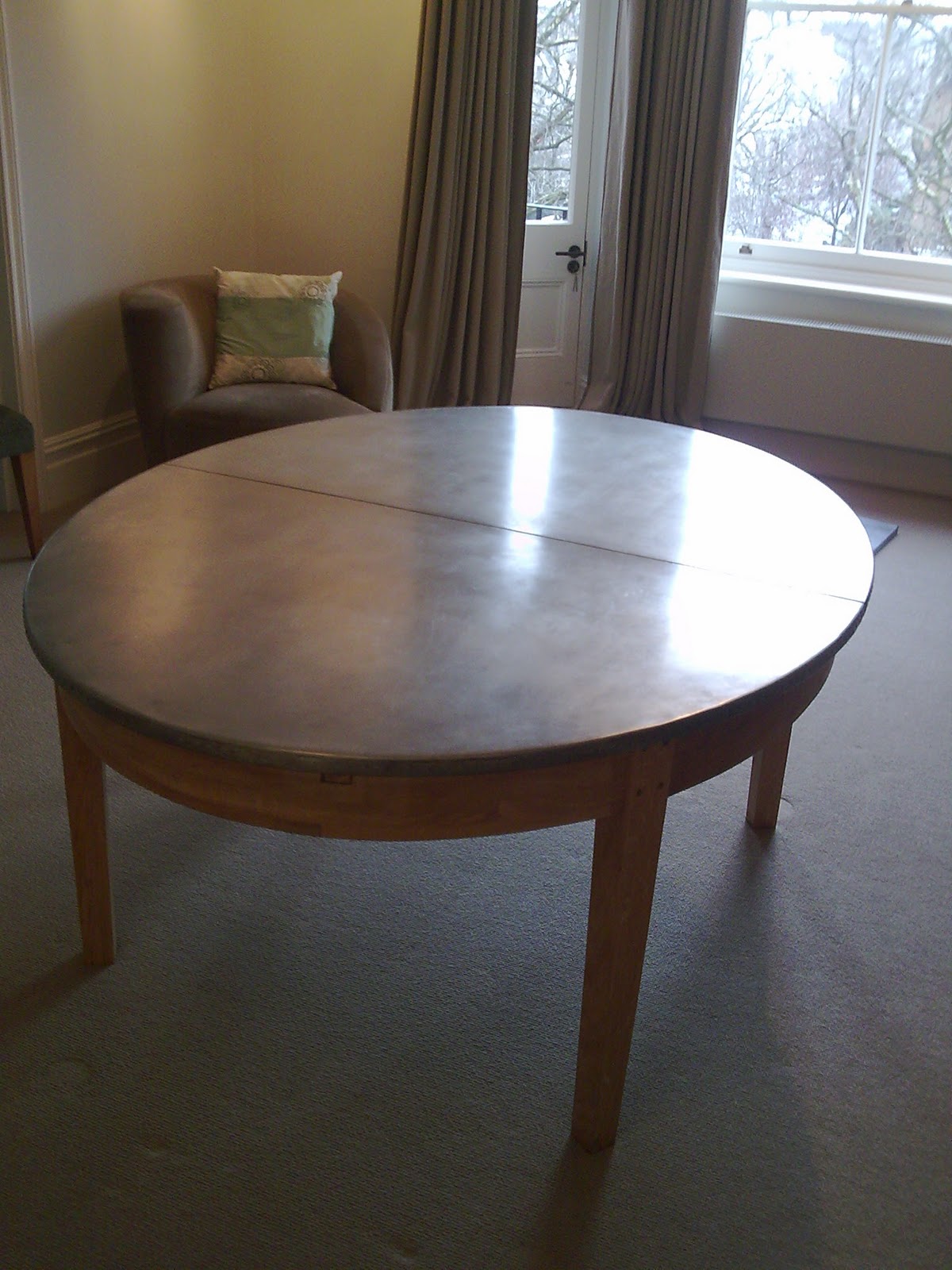 Deballage Designs Oval oak table with a studded zinc top
