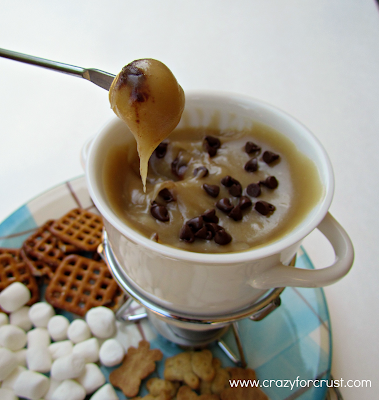 Cookie Dough Fondue {warm cookie dough dip} with fondue fork dipping a cookie
