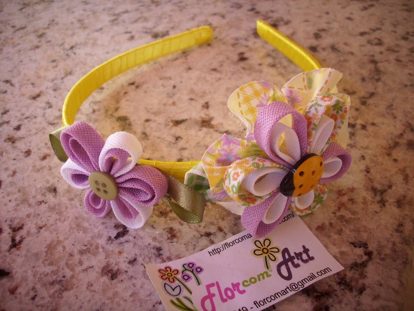 Flor com Art Tiara decorada em cetim amarelo com flor de vies e retalho.