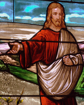Close up of stained glass window of Jesus sowing seeds.