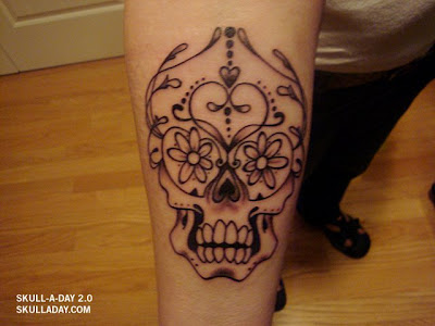Teo roses with girly skull tattoo at girl's upper back.