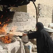 Huda makes bread for her neighbors in exchange for flour. [Photo: Oxfam]