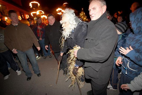 Un vieillard bossu, a son dernier coup de souffle, venant du pier, entoure de gens, torches en main