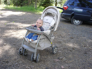 cute baby in front of very very flat rear tire on the van