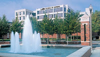 Water fountain foreground in front of a five story white office building labeled as the UAB School of Nursing.