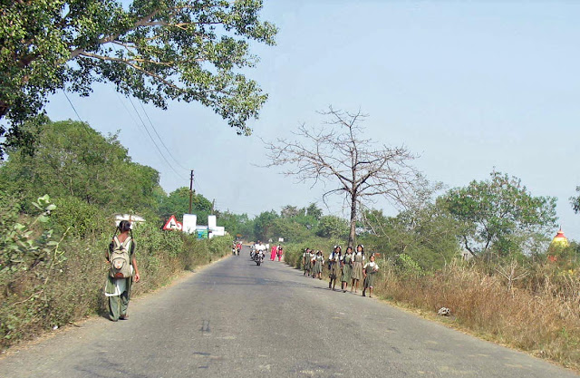 girls in uniform walking to school in rural india
