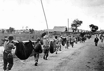 American and Filipino prisoners of war carry makeshift stretchers bearing comrades who dropped during a 70-mile march forced upon them by their Japanese captors in the Philippines in 1942. About 10,000 of the 60,000 prisoners died during the march to prison camps - known as the Bataan Death March. (AP Photo)