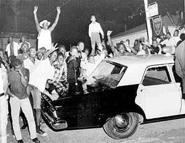 Demonstrators push against a police car in the Watts area of Los Angeles on Aug. 12, 1965, a day after rioting erupted. (AP Photo)
