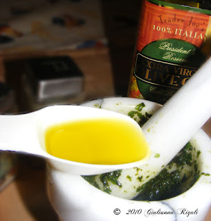 Photo of adding Trader Joe's Olive Oil to Pesto Recipe