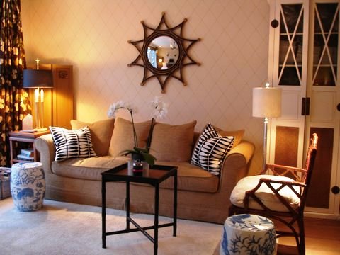 Garden room Ron van Empel of Empel Collections' home with taupe sofa, blue and white Chinese garden stools, sun lamp, a small sidetable, and white cabinets