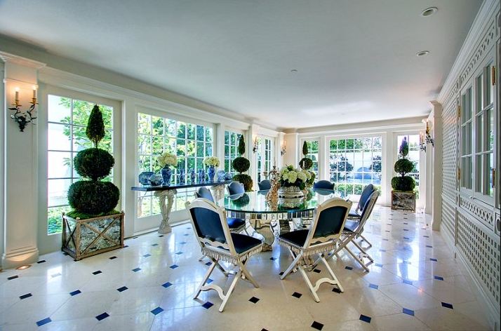 Elegant dining room in a Paul Williams designed home with marble floor and round chrome table with a glass top