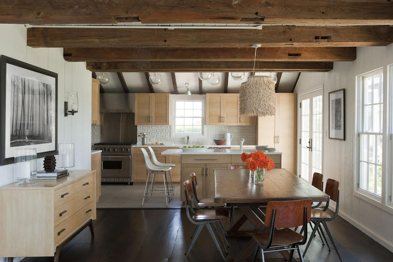 Open kitchen and dining room in the Hamptons with exposed beams and long farmhouse table
