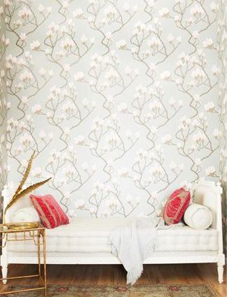 Louis daybed on a hardwood floor, a faux bamboo side table, red accent pillows and floor to ceiling floral wallpaper