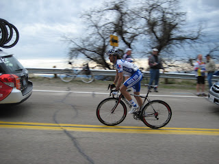 I like this photo of Spaniard Carlos Barredo climbing between the team cars with the blurry tree behind him.