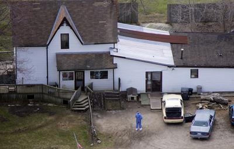 police officer collects evidence at Wayne Kellestine's home