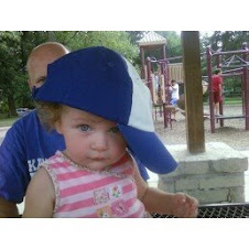 trying on daddy's hat at the park