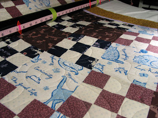 Quilt with "swishing cat tail" design on top, quilted by Angela Huffman