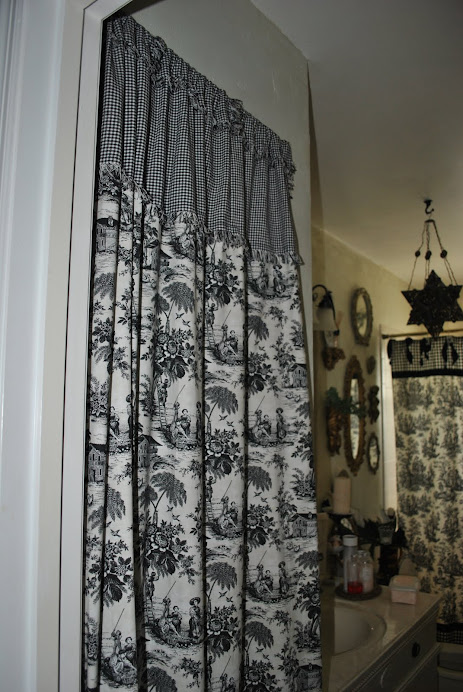 A curtain camouflages a louvered folding closet door