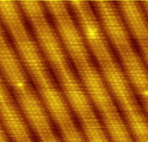 Lámina de oro-100, donde se han resuelto los átomos individuales organizados en su estructura metálica. Imagen obtenida con un microscopio de barrido por efecto túnel cuántico modelo Omicron Low Temperature STM, de RHK Technology electronics. Universidad Tecnológica de Eindhoven (Holanda), 2006.
