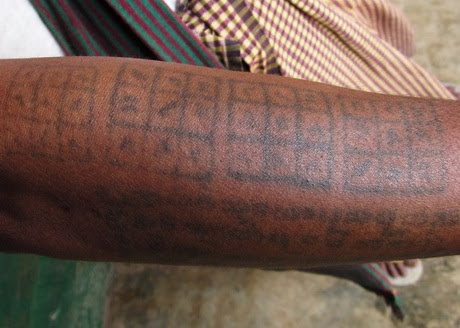 Un brazo tatuado con lo que parecen cuadrados mágicos.