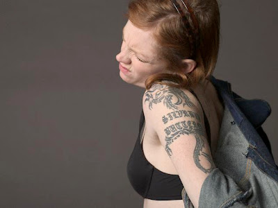 A girl with black dragon tattoo on shoulder to arm.