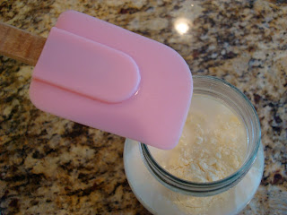 Kefir started added to jar with spatula about to stir