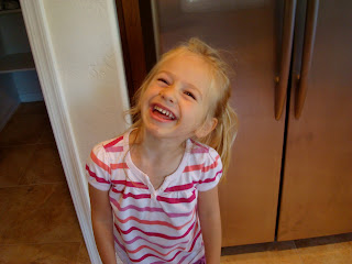 Young girl standing in kitchen giving the biggest smile