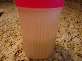 Blender cup with mixed protein powder and water on countertop