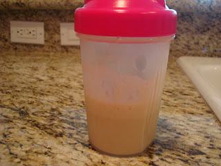 Protein powder mixed with water in blender cup on countertop