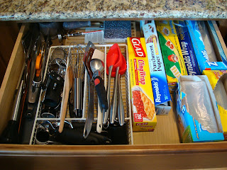 Kitchen drawer filled with utensils, baggies and baking papers