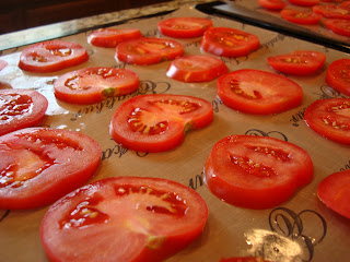 Sliced tomatoes on dehydrator trays flipped over