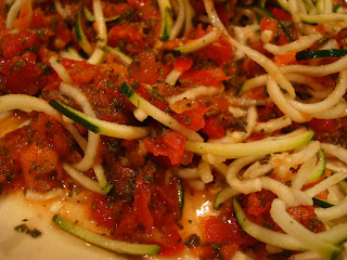 Marinara and zucchini noodles mixed together on plate up close image