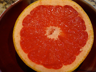 Overhead of sliced grapefruit on red plate