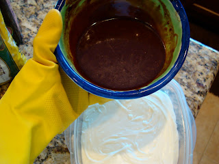 Gloved hand holding melted chocolate and butter mixture over container