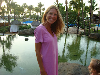 Woman standing and smiling in front of pool