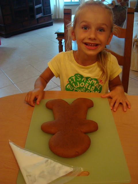 Girl sitting at table with gingerbread man in front of her