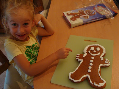Young girl decorating gingerbread man with icing