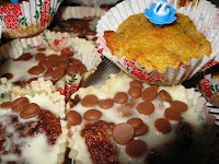 Ugly cupcakes with runny icing, chocolate buttons and a birthday candle