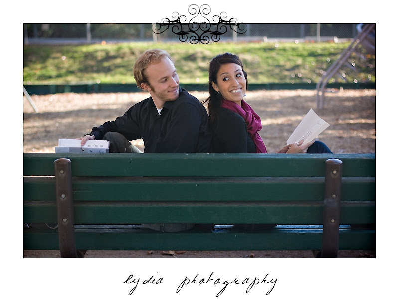 Bride and groom reading and looking at each other at lifestyle park engagement portraits in Auburn, California