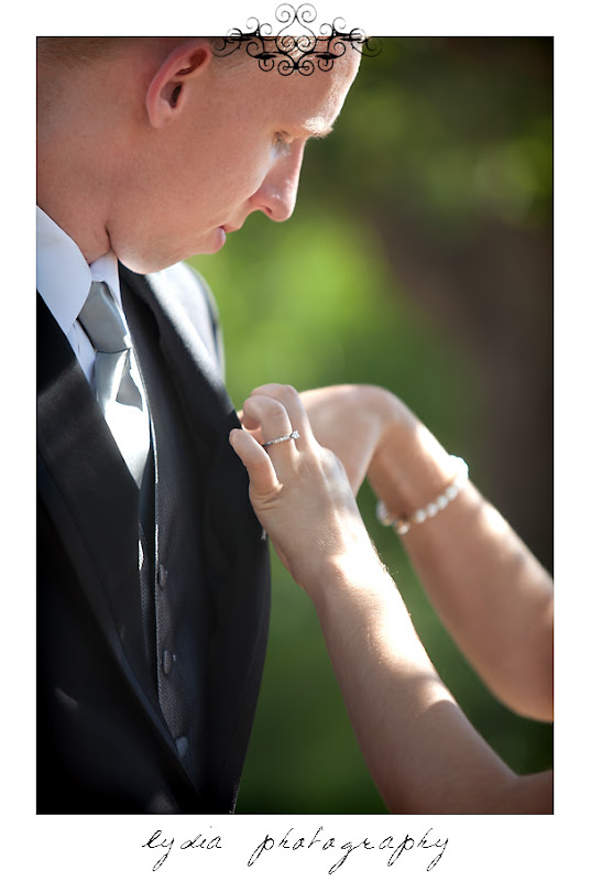 Bride putting a boutonniere on groom at vintage, garden wedding at Empire Mine in Grass Valley, California