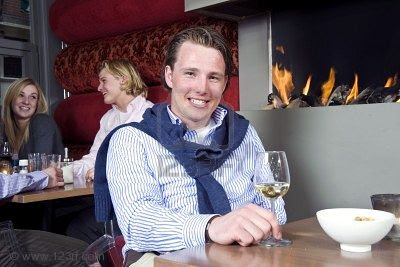 6484887-a-posh-looking-man-with-his-sweater-around-his-neck-and-a-glass-of-white-wine-in-his-hand-sitting-at.jpg