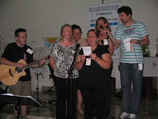 O coral feminino da paróquia cantando no momento cultural o hino " Aqui estou para cantar".