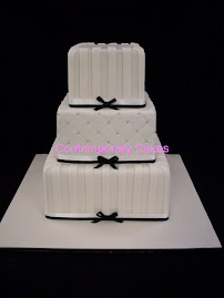 A 3 tier square stacked cake  with a quilted effect middle tier.